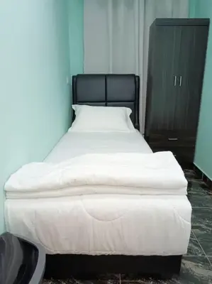 a large white bed in a blue room at SunStar Hotel in Kampong Batu Maung