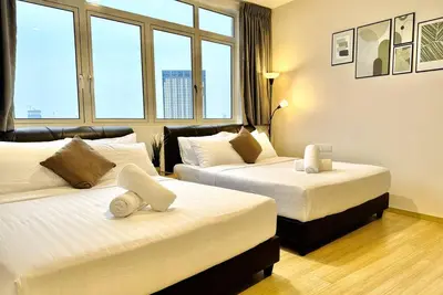 a hotel room with two beds and two windows at Georgetown Seaview 5 Min To Gurney N Straits Quay Washing Machine N Dryer in Tanjong Tokong