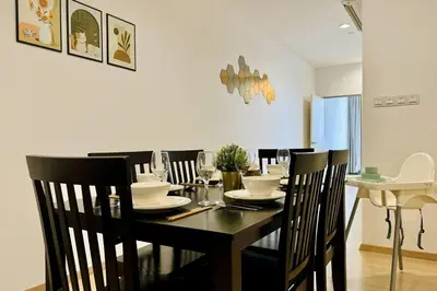 a dining room with a black table and chairs at Georgetown Seaview 5 Min To Gurney N Straits Quay Washing Machine N Dryer in Tanjong Tokong