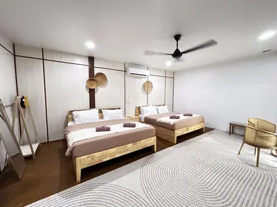 a bedroom with two beds and a ceiling fan at Farmstay Laman Zulfaqar in Lahat