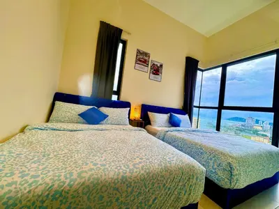 a bedroom with two beds and a large window at The Best Luxury suites Asia Spacious 3BR Sea View in Jelutong