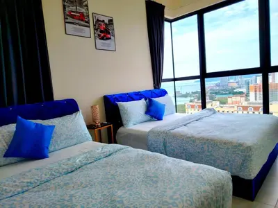 two beds in a room with a large window at Big Family stay urban Large Pool & Sea view Netfix in Jelutong