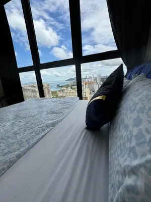a bed in a room with a large window at Big Family stay urban Large Pool & Sea view Netfix in Jelutong