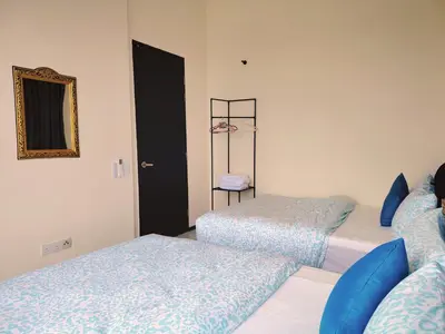 a room with two beds and a shelf with a mirror at Big Family stay urban Large Pool & Sea view Netfix in Jelutong