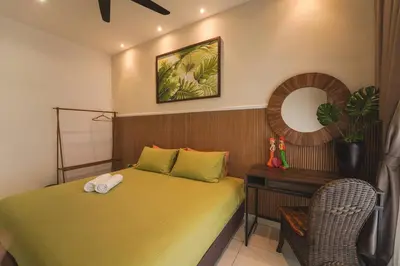 a bedroom with a bed and a chair and a mirror at Horizon Ipoh 8Pax 3R2B - Tropical Bali Retreat in Ipoh