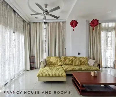 a living room with a yellow couch and a ceiling fan at Castle Bungalow In Bercham Ipoh in Kampong Tasek
