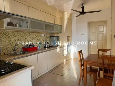 a kitchen with white cabinets and a table and chairs at Castle Bungalow In Bercham Ipoh in Kampong Tasek