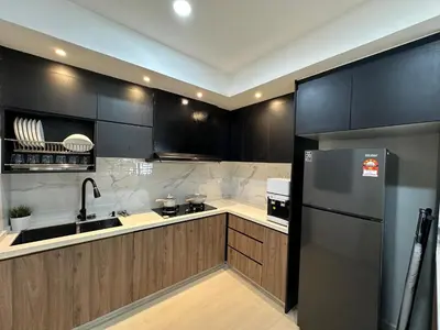 a kitchen with black cabinets and a stainless steel refrigerator at 3Story Family Suites 7pax Ikea Batu Kawan 5min in Batu Kawan