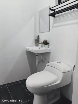 a white bathroom with a toilet and a sink at Veneto Ipoh homestay 3BR with infinity pool in Ipoh