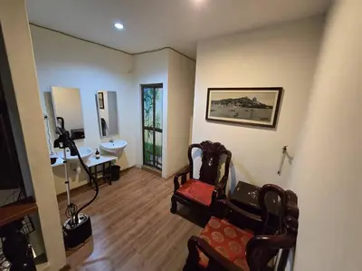 a living room with a chair and a mirror at HOME Penang in George Town