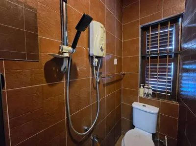 a shower in a bathroom with a toilet at HOME Penang in George Town