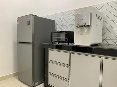 a kitchen with a refrigerator and a coffee maker at Eco Homestay in Teluk Intan