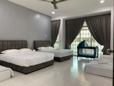 a bedroom with two beds and a piano in it at Eco Homestay in Teluk Intan