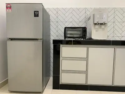 a kitchen with a refrigerator and a microwave at Eco Homestay in Teluk Intan