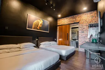 a bedroom with two beds and a brick wall at Ipoh The Label by Verve in Kampong Simee