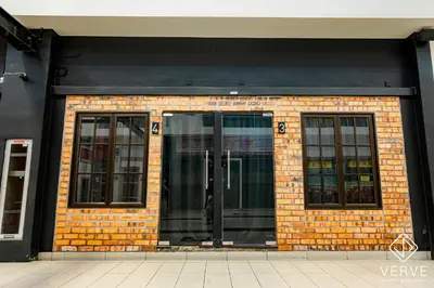 a brick building with two glass doors on it at Ipoh The Label by Verve in Kampong Simee