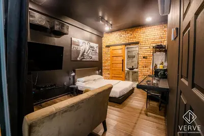 a bedroom with a bed and a couch and a television at Ipoh The Label by Verve in Kampong Simee