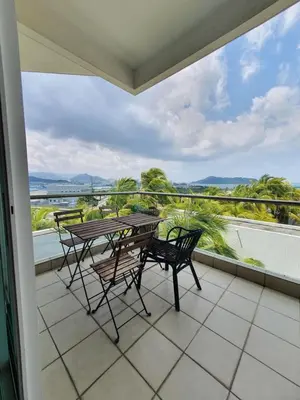 a balcony with tables and chairs and a view of the ocean at Southbay Seaview Condo A2 10minQueensbay 10minSpice in Bayan Lepas