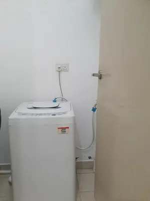 a small white bathroom with a washer and a white refrigerator at Southbay Seaview Condo A2 10minQueensbay 10minSpice in Bayan Lepas