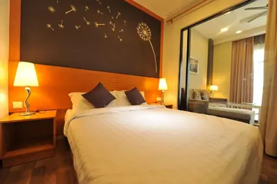 a bedroom with a large white bed with birds on the wall at Cameron Nova Highlands Resorts in Brinchang