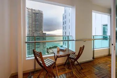 a balcony with a table and chairs and a large window at 2R2B Seaview Serenity 1 to 8pax Gurney Mansion One in George Town