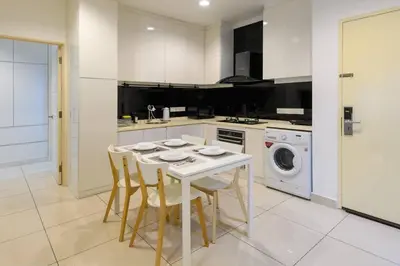 a kitchen with a table and chairs and a washing machine at 2R2B Seaview Serenity 1 to 8pax Gurney Mansion One in George Town