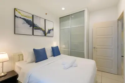 a bedroom with a large white bed with blue pillows at 2R2B Seaview Serenity 1 to 8pax Gurney Mansion One in George Town