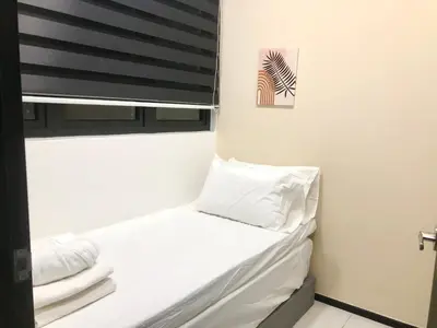 a small bed in a room with a window at Urban Suite Condominium By Blue Sky Holidays in Jelutong