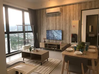 a living room with a television and a table and chairs at Urban Suite Condominium By Blue Sky Holidays in Jelutong