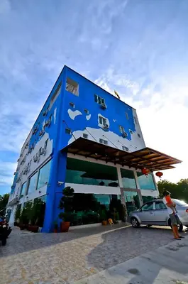 a blue building with a car parked in front of it at Yew Boutique Hotel in Teluk Intan