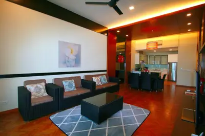 a living room with couches and a table and a kitchen at Profolio @ Straits Quay in George Town