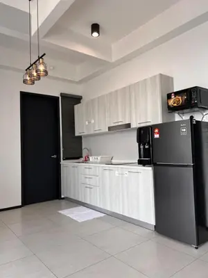 a kitchen with a black refrigerator and white cabinets at Georgetown Urban Family & Baby-Friendly Home with Skypool Seaview in Jelutong