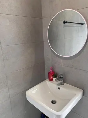 a bathroom with a white sink and a mirror at Georgetown Urban Family & Baby-Friendly Home with Skypool Seaview in Jelutong