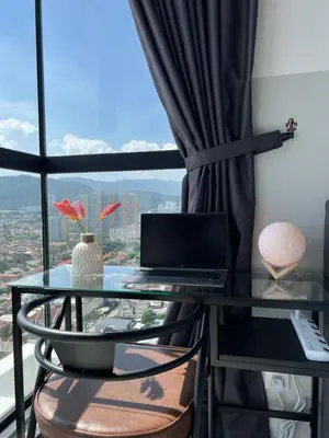 a desk with a laptop on a glass table with a window at Georgetown Urban Family & Baby-Friendly Home with Skypool Seaview in Jelutong