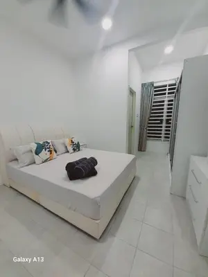 a white bedroom with a large bed in a room at Yarra SP Homestay in Sungai Petani