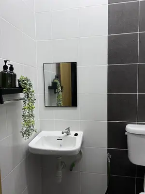 a bathroom with a sink and a mirror and a toilet at Casa Kita Homestay in Bandar Baharu