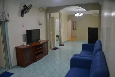 a living room with a blue couch and a tv at Yim's Homestay in Kuala Kubu Baharu