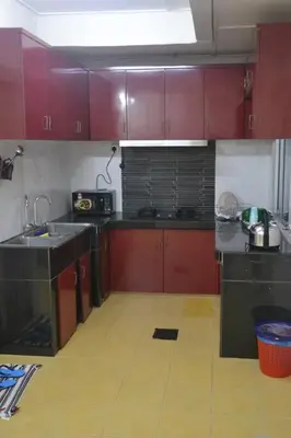 a kitchen with red cabinets and a yellow floor at Yim's Homestay in Kuala Kubu Baharu