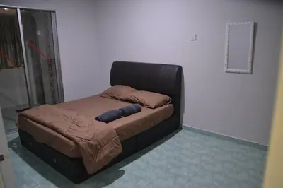 a bed in a room with a black bed frame at Yim's Homestay in Kuala Kubu Baharu