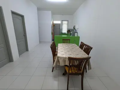 a dining room with a table and chairs and a kitchen at HOMESTAY IBUNDA Sabak Bernam in Sabak Bernam