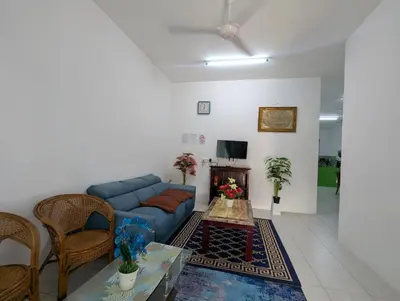 a living room with a blue couch and a table at HOMESTAY IBUNDA Sabak Bernam in Sabak Bernam