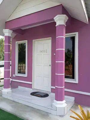 a pink house with a white door and windows at D'SQ Homestay in Tanjung Karang
