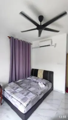 a bed in a room with a ceiling fan at D'SQ Homestay in Tanjung Karang