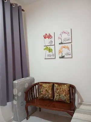 a room with a bench and some pictures on the wall at D'SQ Homestay in Tanjung Karang