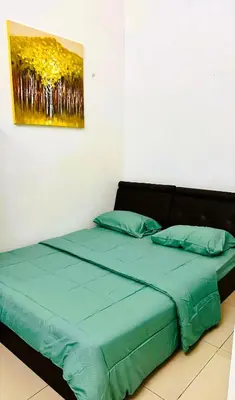 a bed in a room with a painting on the wall at Cozy Homestay in Ipoh