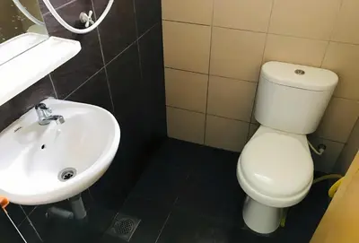 a bathroom with a white toilet and a sink at Cozy Homestay in Ipoh