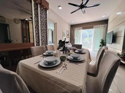 a dining room table with chairs and a ceiling fan at Ipoh Lakeside Apartment with Mountain View in Kampong Batu Lapan