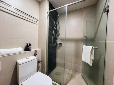 a bathroom with a glass shower stall and a toilet at Ipoh Lakeside Apartment with Mountain View in Kampong Batu Lapan