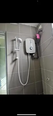 a shower in a bathroom with a hose on the wall at Zaf's Stay in Kampong Malim Nawar
