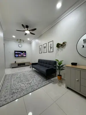 a living room with a couch and a tv at Namel Homestay Taiping in Kampong Jana
